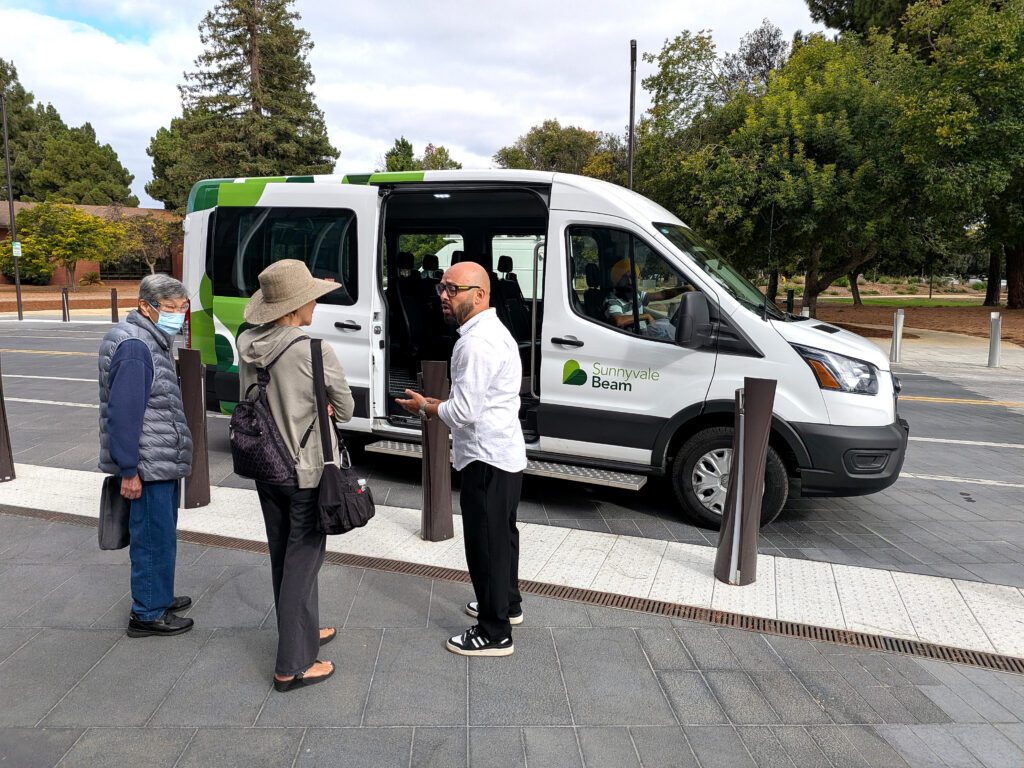People standing in front of a ride-hailing vehicle in Sunnyvale, California