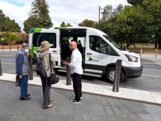 People standing in front of a ride-hailing vehicle in Sunnyvale, California