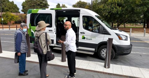 People standing in front of a ride-hailing vehicle in Sunnyvale, California