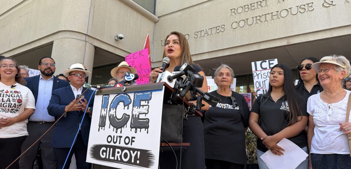 A woman speaking at a podium outside a courthouse in San Jose, California