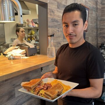 A man holding food on a plate in a restaurant in San Jose, California