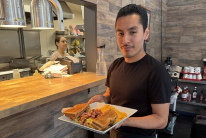 A man holding food on a plate in a restaurant in San Jose, California