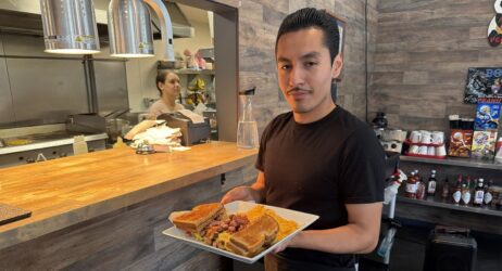 A man holding food on a plate in a restaurant in San Jose, California