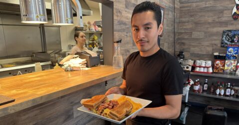 Un hombre sostiene comida en un plato en un restaurante en San José, California.