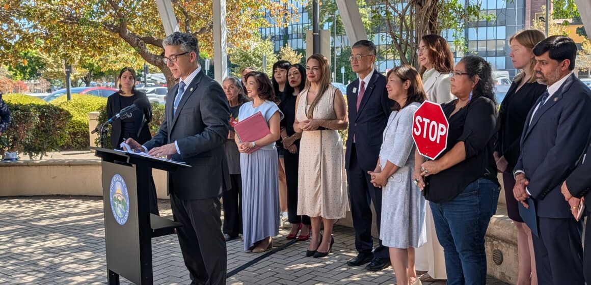 ICE Injunction 9/14/26 A man speaks at a podium outside with a row of people standing behind him in San Jose, California