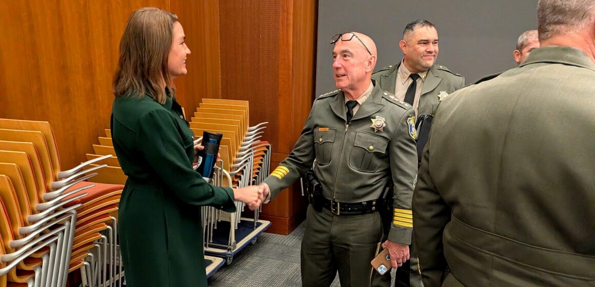 Sheriff and Cupertino Mayor A man and woman shaking hands at a government meeting in Cupertino, California