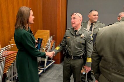 A man and woman shaking hands at a government meeting in Cupertino, California