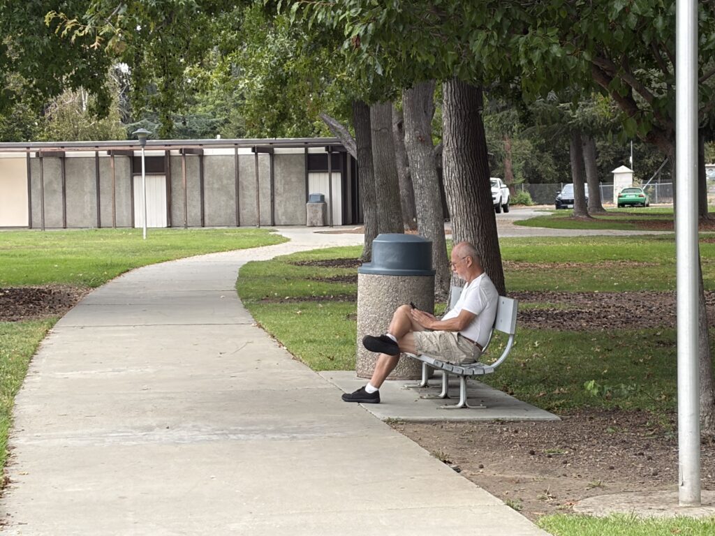 A man sitting on a park bench in Santa Clara, California