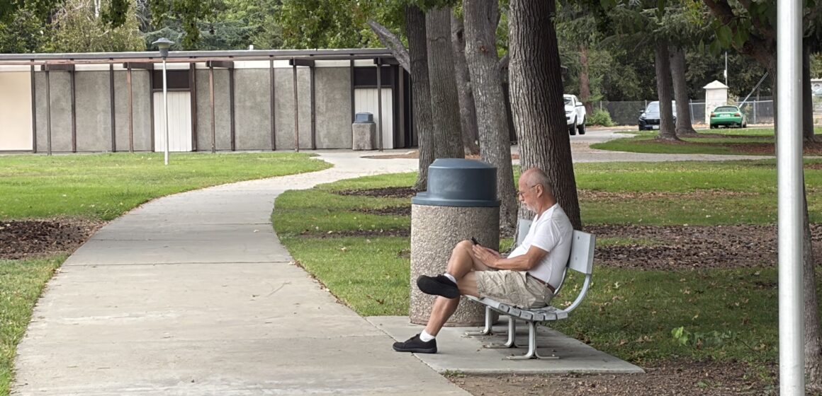A man sitting on a park bench in Santa Clara, California