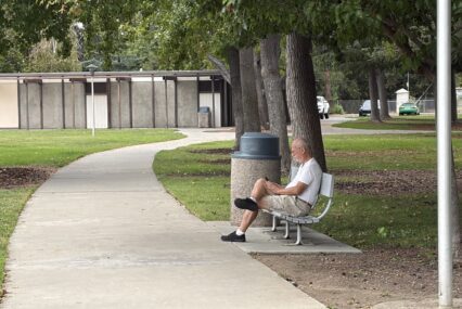 A man sitting on a park bench in Santa Clara, California