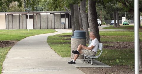 A man sitting on a park bench in Santa Clara, California