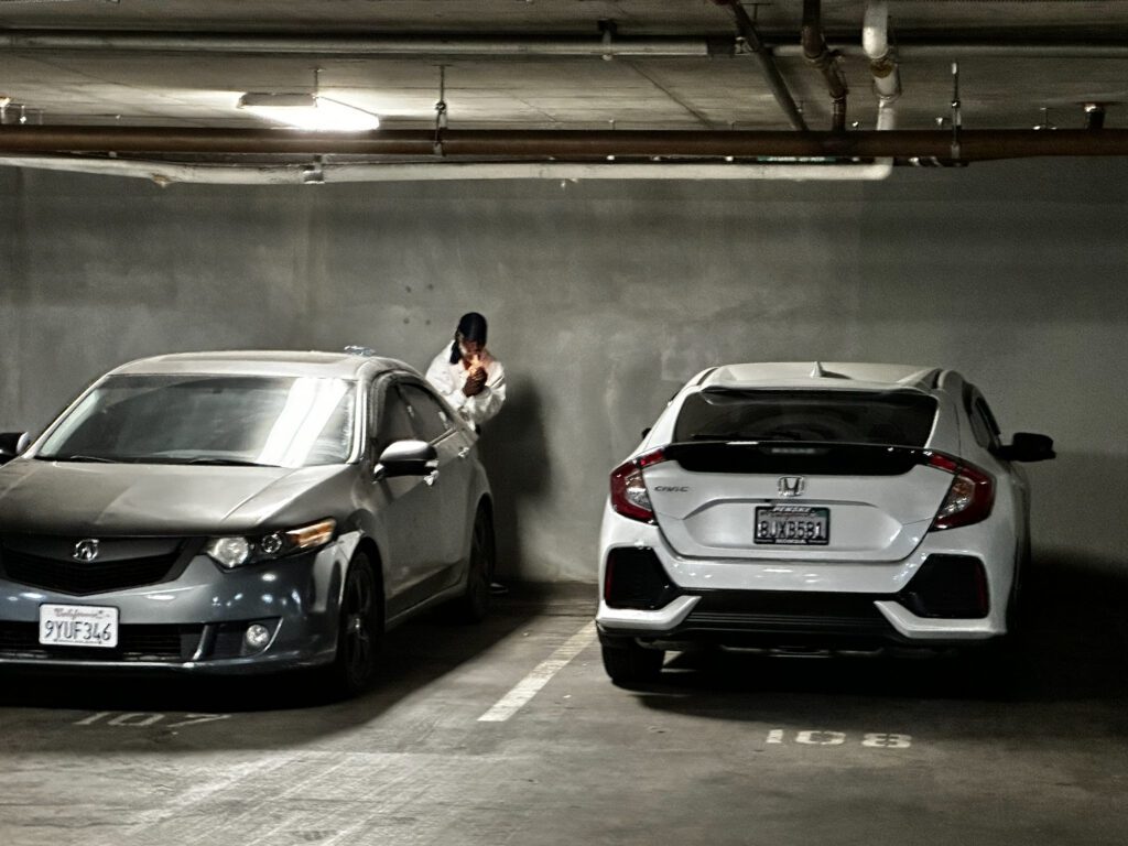 A man standing behind a car in a garage