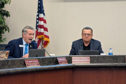 Two men sitting at a dais at a school board meeting in San Jose, California