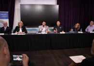 A row of people sitting behind a table at an election forum in Santa Clara, California