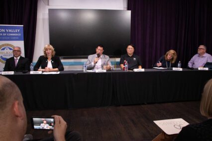 A row of people sitting behind a table at an election forum in Santa Clara, California