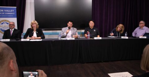 A row of people sitting behind a table at an election forum in Santa Clara, California
