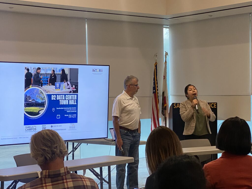 People conducting a presentation in front of a projector screen