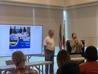 People conducting a presentation in front of a projector screen
