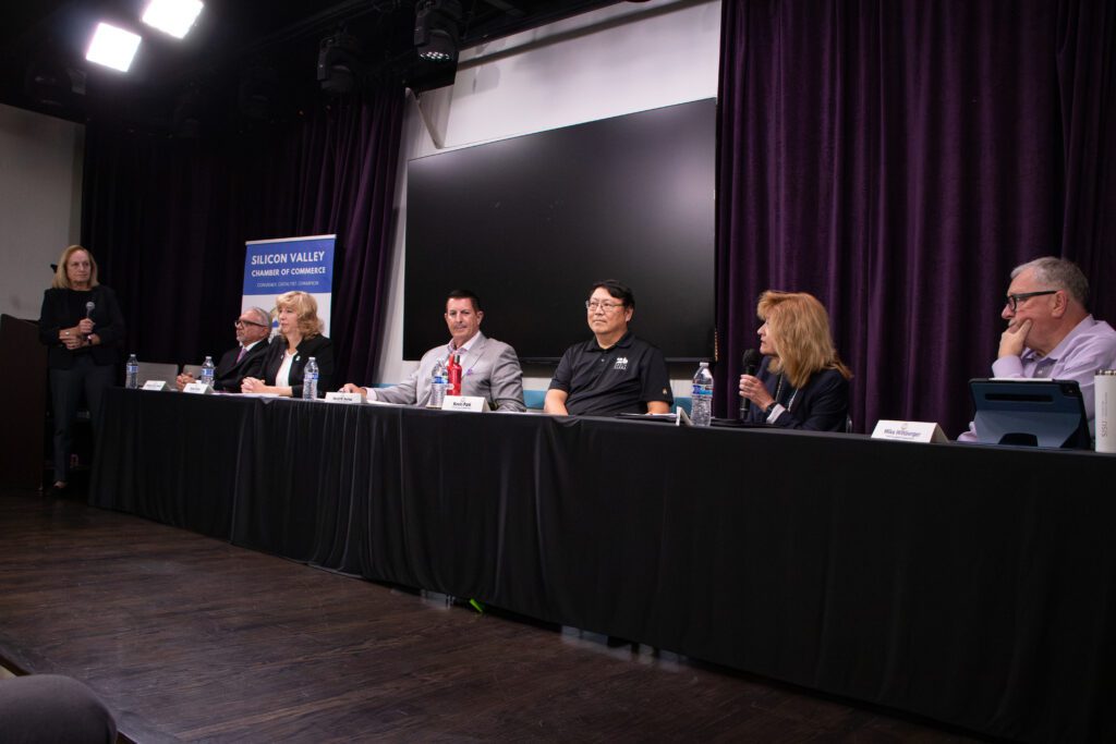 A row of people sitting at a table during an election candidate forum in Santa Clara, California
