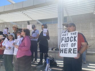 FLOCK CAMERAS RALLY SAN JOSE People holding signs at a rally opposed to automatic license plate readers in San Jose, California