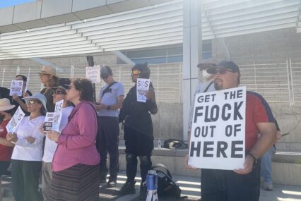 People holding signs at a rally opposed to automatic license plate readers in San Jose, California