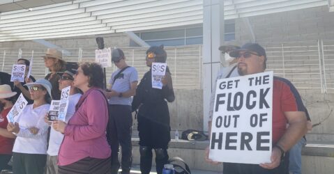 People holding signs at a rally opposed to automatic license plate readers in San Jose, California