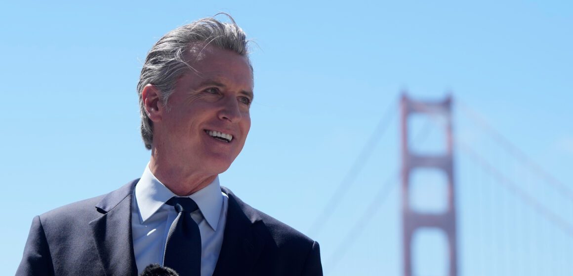 California Gov. Gavin Newsom The governor of California standing in at a microphone, with the Golden Gate Bridge in the background