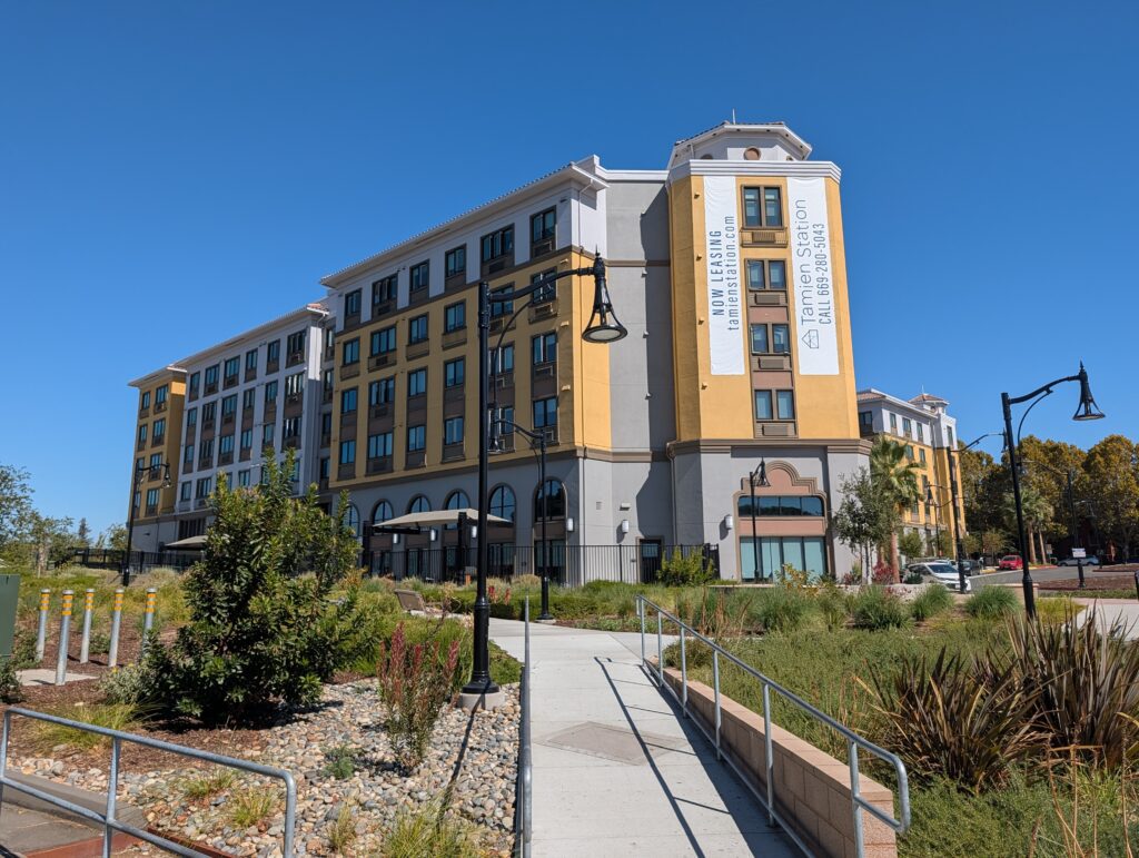 The exterior of an apartment complex near public transit in San Jose, California