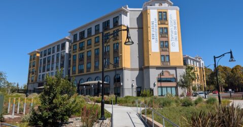 The exterior of an apartment complex near public transit in San Jose, California
