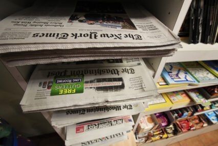 A stack of newspapers in a media rack