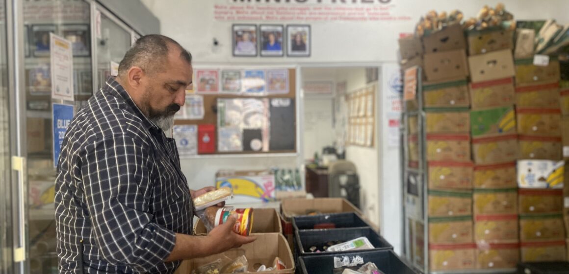 Lighthouse Food Pantry-- Pastor Ralph Olmos A man looking at produce at a food pantry in San Jose, California