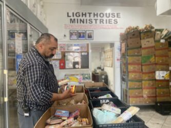 Lighthouse Food Pantry-- Pastor Ralph Olmos A man looking at produce at a food pantry in San Jose, California
