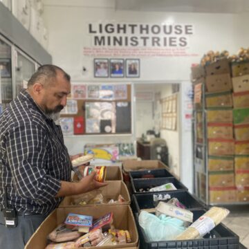 Lighthouse Food Pantry-- Pastor Ralph Olmos A man looking at produce at a food pantry in San Jose, California