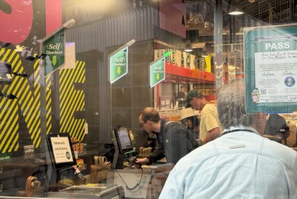 Shoppers scan goods in a self-checkout line.