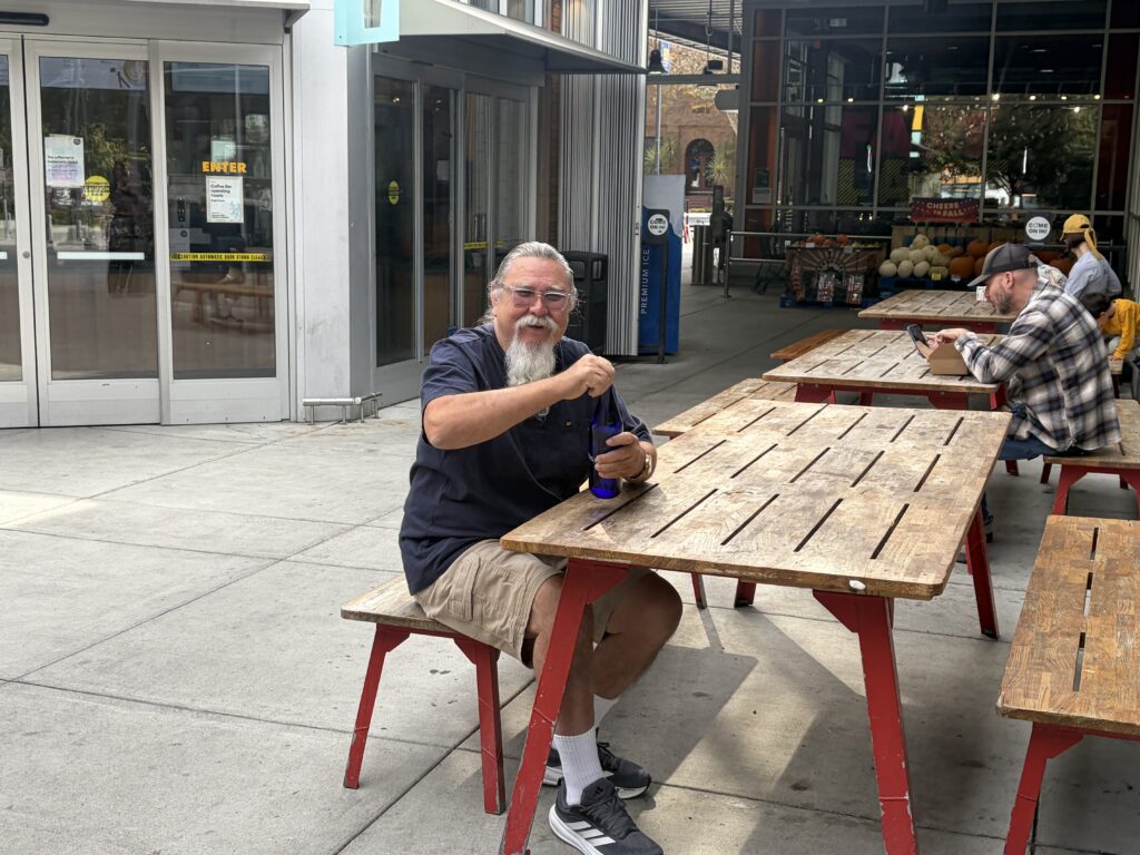 Man sitting on a bench by a picnic table