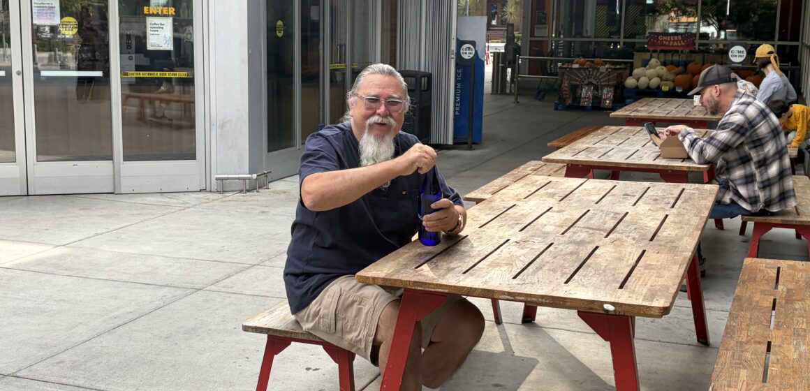 Man sitting on a bench by a picnic table