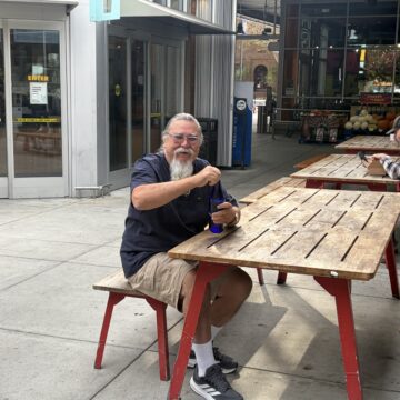 Man sitting on a bench by a picnic table