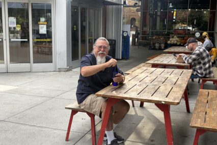 Man sitting on a bench by a picnic table