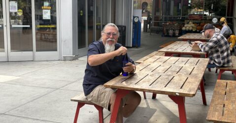 Man sitting on a bench by a picnic table