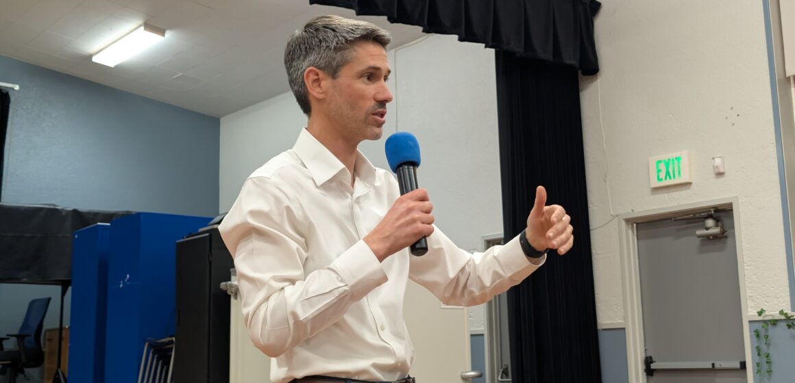 A man in a white collar shirt holding a microphone
