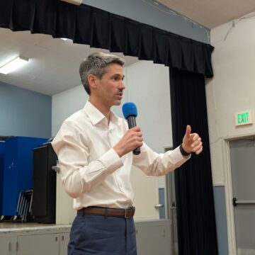 A man in a white collar shirt holding a microphone