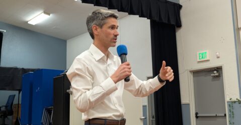 A man in a white collar shirt holding a microphone