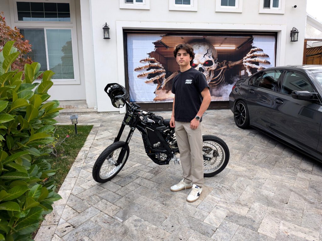 A teenage boy standing next to an electric bike