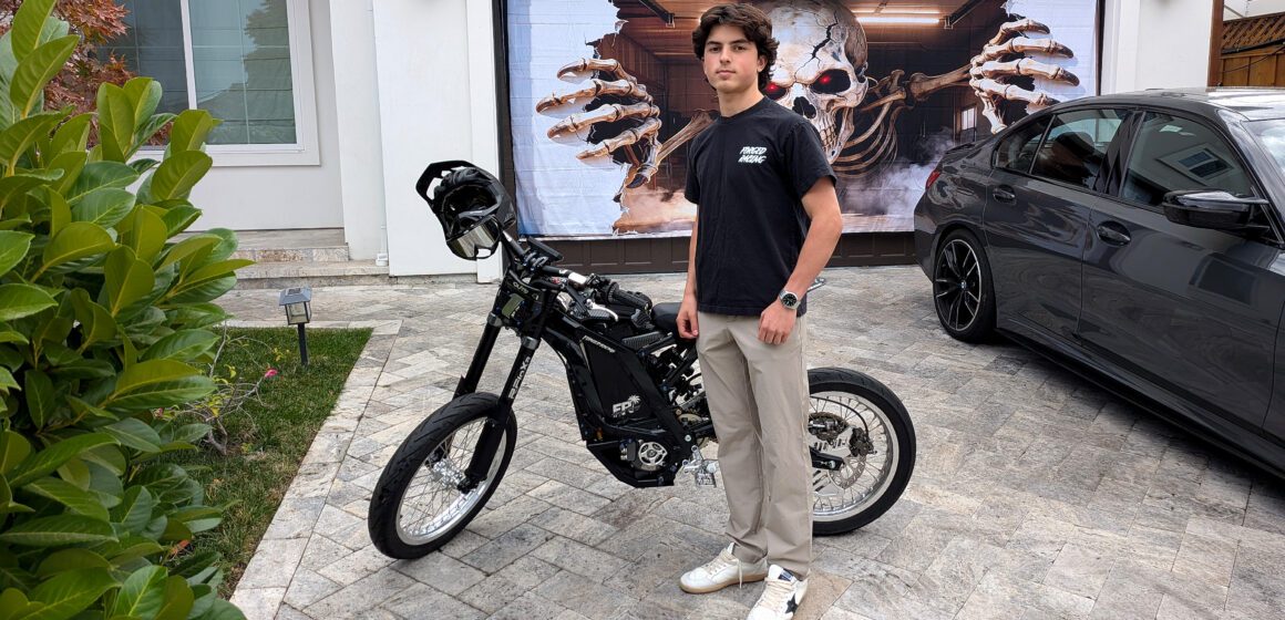 LG E-BIKE: Emirali Mazanov A teenage boy standing next to an electric bike