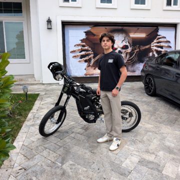 A teenage boy standing next to an electric bike