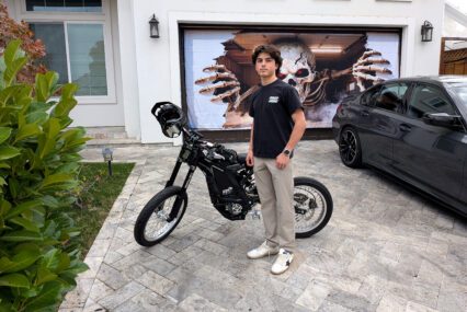 A teenage boy standing next to an electric bike