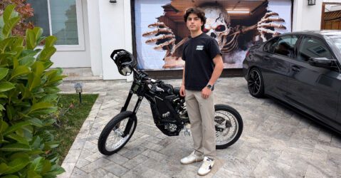 A teenage boy standing next to an electric bike