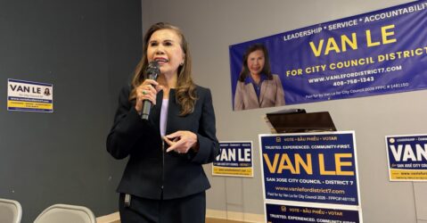 A women speaks at a microphone.