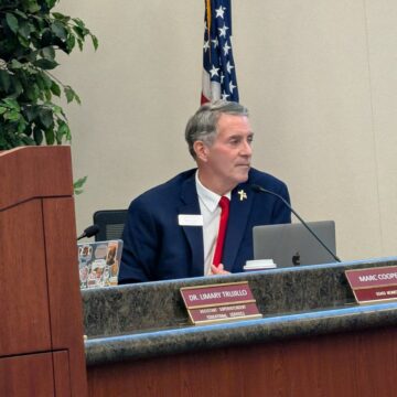 A man sitting at a dais at a school board meeting in San Jose, California